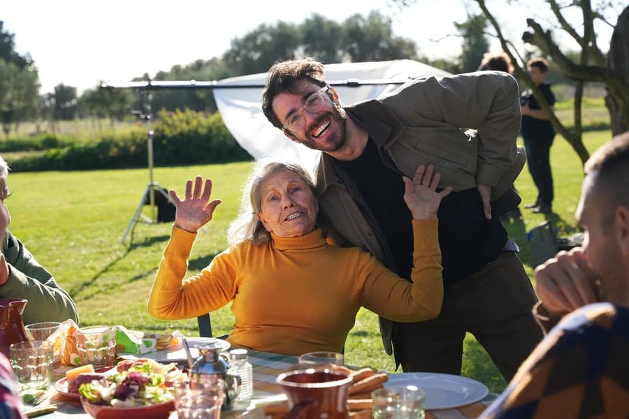 Two of the team waving on an outdoor set