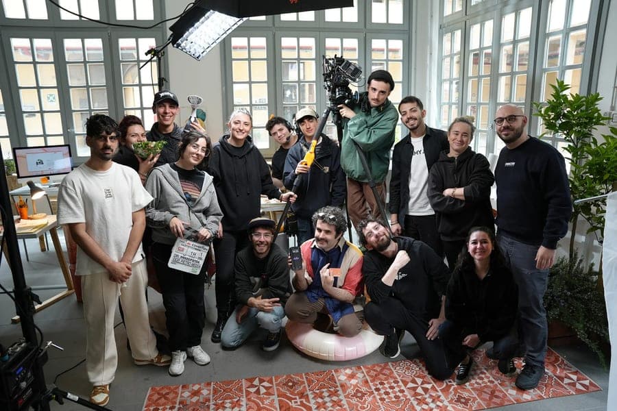 The whole crew in a group photo inside a glasshouse